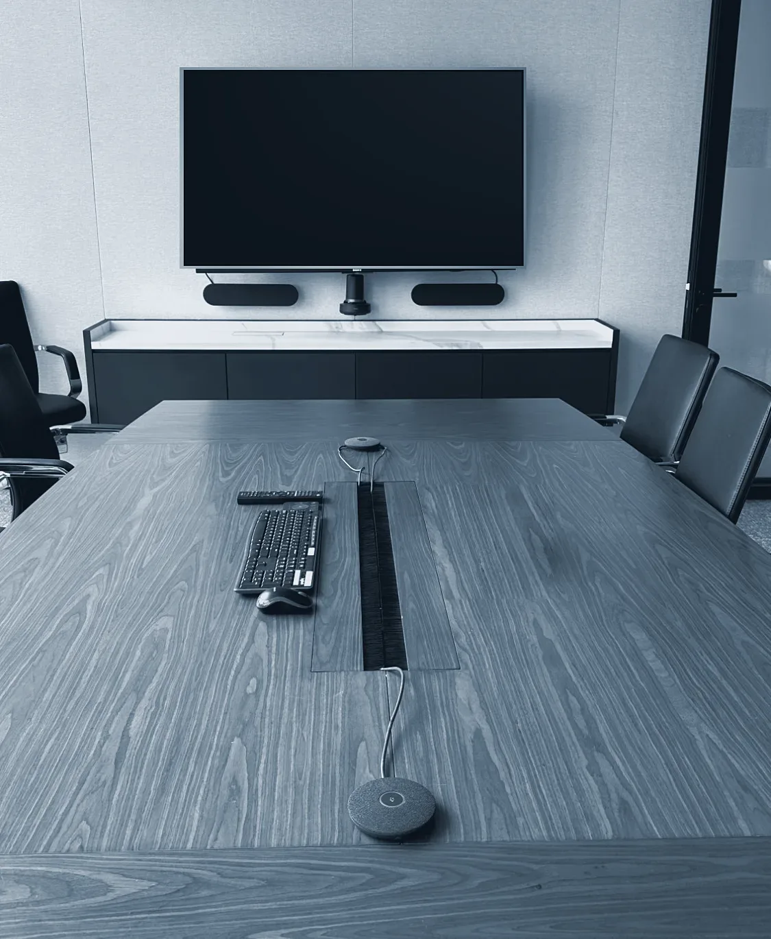 The boardroom in the new office, with a wall screen, camera and table microphones